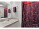 Bathroom featuring single sink vanity and decorative floral shower curtain at 370 Shiloh Rd, Statesville, NC 28677
