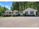 Charming single-story home with a covered porch, black shutters, mature trees and an expansive paved driveway at 370 Shiloh Rd, Statesville, NC 28677