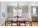 Cozy dining room with chandelier, wainscoting and a large window with blinds overlooking the yard at 371 Luray Way, Rock Hill, SC 29730