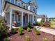 Charming front porch featuring a cozy swing, white columns, and hanging plants, perfect for relaxing outdoors at 371 Luray Way, Rock Hill, SC 29730