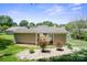 View of a beautifully landscaped backyard with a covered patio and blooming rose bushes at 374 Queens Sw Dr, Concord, NC 28025