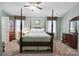 Primary bedroom features a four poster bed, ceiling fan, and coordinating window treatments at 374 Queens Sw Dr, Concord, NC 28025