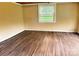A quaint bedroom with laminate wood flooring and a window to let in natural light at 374 Queens Sw Dr, Concord, NC 28025