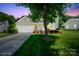 Charming home with an attached garage and a meticulously maintained lawn and garden at 374 Queens Sw Dr, Concord, NC 28025