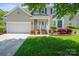Charming home featuring a well-manicured lawn, attached garage, and welcoming front porch at 374 Queens Sw Dr, Concord, NC 28025