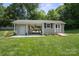 Rear view of the tan outbuilding with patio space and attractive landscaping at 374 Queens Sw Dr, Concord, NC 28025