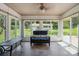 Cozy sunroom with a wicker couch with view of the backyard and exterior building at 374 Queens Sw Dr, Concord, NC 28025