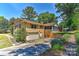A spacious backyard with a brick patio, screened porch, and a two-car garage, perfect for outdoor living at 385 Gum Branch Rd, Charlotte, NC 28214