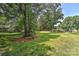 Picturesque backyard featuring a large grassy area, mature trees, and landscaped flowerbeds at 385 Gum Branch Rd, Charlotte, NC 28214
