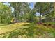 Spacious backyard with mature trees and lush greenery offering a private outdoor space at 385 Gum Branch Rd, Charlotte, NC 28214