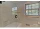 Bright bathroom with tiled walls, glass enclosed tub/shower, and a window providing lots of natural light at 385 Gum Branch Rd, Charlotte, NC 28214