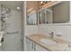 Bright bathroom features white tile shower with grab bars, and a vanity with a marble countertop and chrome faucet at 385 Gum Branch Rd, Charlotte, NC 28214