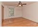Bright bedroom has wood floors, a modern ceiling fan, white walls, and window letting in natural light at 385 Gum Branch Rd, Charlotte, NC 28214