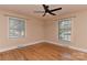 Bright bedroom with hardwood floors, two windows for lots of natural light, and a modern ceiling fan at 385 Gum Branch Rd, Charlotte, NC 28214