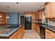 Open kitchen with a large island, black appliances, and travertine floors at 385 Gum Branch Rd, Charlotte, NC 28214