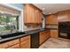 Kitchen with wooden cabinets, black appliances, and stone countertops at 385 Gum Branch Rd, Charlotte, NC 28214