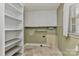 Functional laundry room with white cabinetry, shelving, and a tiled floor at 385 Gum Branch Rd, Charlotte, NC 28214