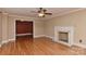 Bright living room with hardwood floors, fireplace, ceiling fan, and large doorway at 385 Gum Branch Rd, Charlotte, NC 28214