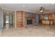 Cozy living room with a brick fireplace, open shelving, and travertine floors at 385 Gum Branch Rd, Charlotte, NC 28214