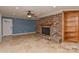 Living room featuring travertine flooring, a brick fireplace, and built-in shelving at 385 Gum Branch Rd, Charlotte, NC 28214