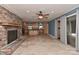 Open-concept living space with a brick fireplace, travertine flooring, and access to the kitchen at 385 Gum Branch Rd, Charlotte, NC 28214