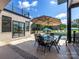 Back patio with a dining area near the outdoor kitchen and a serene view of the pool and greenery at 4315 Hartis Grove Church Rd, Indian Trail, NC 28079