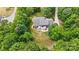 Aerial view of home showing mature trees, lawn, driveway, and brick exterior with patio at 4570 Chanel Ct, Concord, NC 28025