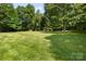 Sprawling backyard with mature trees, grassy lawn, and wooden shed at 4570 Chanel Ct, Concord, NC 28025