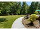 View of backyard featuring manicured lawn, decorative foliage, shed, and patio at 4570 Chanel Ct, Concord, NC 28025