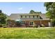 Spacious backyard with a brick patio, lush green lawn, and mature trees, perfect for outdoor relaxation and entertainment at 4570 Chanel Ct, Concord, NC 28025