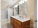 Well-lit bathroom featuring a double sink vanity with wood cabinets and framed mirrors at 4570 Chanel Ct, Concord, NC 28025