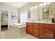 Bright bathroom featuring a soaking tub, dual vanity sinks, and a window at 4570 Chanel Ct, Concord, NC 28025