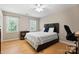 Cozy bedroom with hardwood floors, a comfortable bed, workspace, and natural light at 4570 Chanel Ct, Concord, NC 28025
