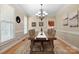 Traditional dining room featuring a wooden table, stylish chandelier, and elegant décor with natural light streaming through windows at 4570 Chanel Ct, Concord, NC 28025
