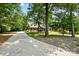 Long driveway leading to the lovely brick home surrounded by lush greenery and mature trees providing privacy and serenity at 4570 Chanel Ct, Concord, NC 28025