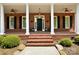 Charming brick home featuring a covered front porch with stately columns and manicured landscaping at 4570 Chanel Ct, Concord, NC 28025