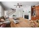 Cozy living room with hardwood floors, a fireplace, built-in bookshelves, and a ceiling fan for a comfortable atmosphere at 4570 Chanel Ct, Concord, NC 28025