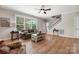 Sunlit living room featuring hardwood floors, large window, and access to the staircase at 4570 Chanel Ct, Concord, NC 28025