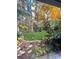 Inviting backyard view featuring green grass, mature trees, and pink flowering bushes at 5321 Kathryn Blair Ln, Charlotte, NC 28226