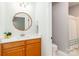 Bright bathroom featuring a single sink vanity, round mirror, and shower/tub with curtain at 5321 Kathryn Blair Ln, Charlotte, NC 28226