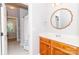 Bright bathroom with a wood vanity, decorative mirror, and tub/shower in the background at 5321 Kathryn Blair Ln, Charlotte, NC 28226