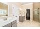 Bathroom featuring dual sinks, vanity, tiled floors, and glass shower, providing a luxurious space at 5321 Kathryn Blair Ln, Charlotte, NC 28226