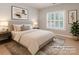 A staged bedroom features neutral colors, a large window, and simple decor at 5321 Kathryn Blair Ln, Charlotte, NC 28226