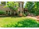 Brick home exterior featuring a manicured lawn, mature landscaping, and a charming wooden deck at 5321 Kathryn Blair Ln, Charlotte, NC 28226