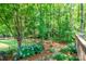 The deck looks out over lush backyard landscaping with trees, shrubs, and flower beds at 5321 Kathryn Blair Ln, Charlotte, NC 28226