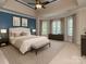 A primary bedroom featuring tray ceilings, a ceiling fan, and many windows at 5321 Kathryn Blair Ln, Charlotte, NC 28226