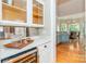 Entertainer's wet bar featuring quartz countertops, glass shelving, and a wine refrigerator at 5321 Kathryn Blair Ln, Charlotte, NC 28226
