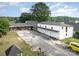 Spacious property featuring a home, large driveway with garage, and outdoor play area, all surrounded by trees at 565 Shore Acres Rd, Salisbury, NC 28146