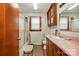 Bathroom features a shower, vanity, pink countertop, wooden cabinets, and window at 565 Shore Acres Rd, Salisbury, NC 28146