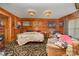Bedroom featuring wood walls, two chandeliers and a patterned rug at 565 Shore Acres Rd, Salisbury, NC 28146
